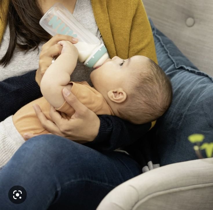 Nestled in the warmth of a mother's embrace, the baby drinks milk peacefully, tiny fingers curled against her skin. With each gentle sip, comfort and love flow as naturally as the bond between them.